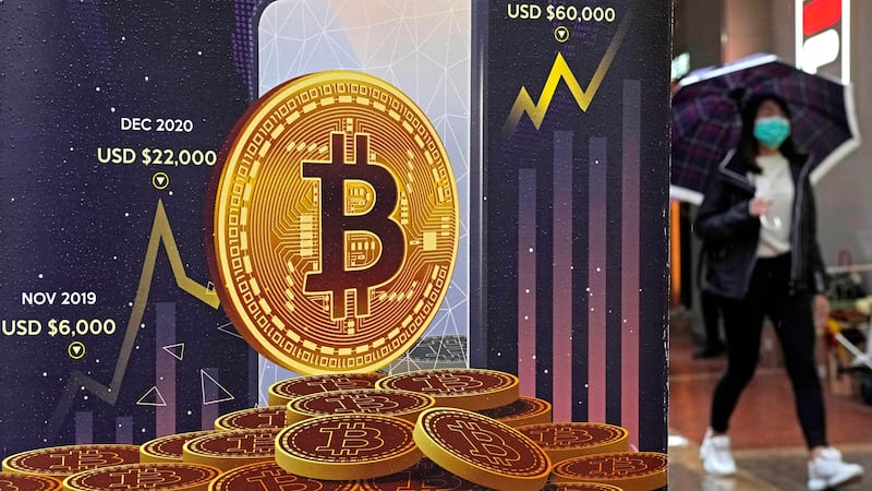 FILE - An advertisement for Bitcoin cryptocurrency is displayed on a street in Hong Kong, on...